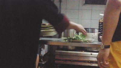 7月23日，漢麗軒烤肉超市昌平店，服務員將幾盤顧客剩菜（左手中疊在一起的是幾盤肉，其右手正整理韭菜）端回后廚，進行整理后準備再送往餐廳自助取餐區供顧客食用。